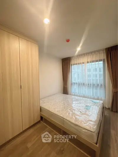 Cozy bedroom with wooden wardrobe and large window for natural light