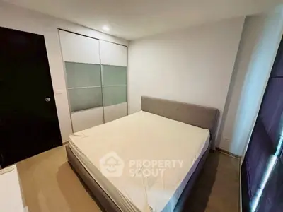 Cozy bedroom with modern design and ample natural light, featuring a comfortable bed and sleek wardrobe.