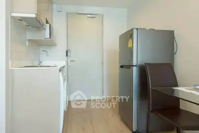 Modern kitchen with sleek appliances and dining area in compact layout