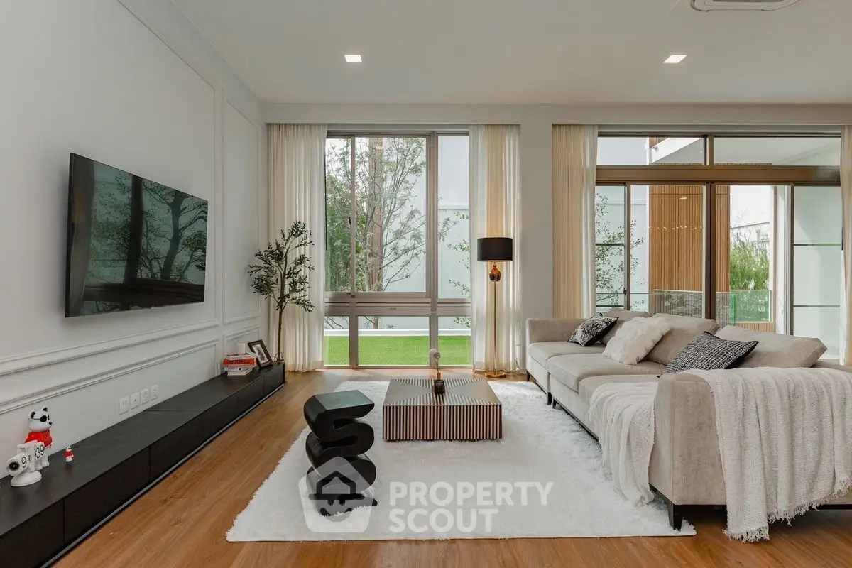 Luxurious living room with modern decor, large windows, and cozy seating area.