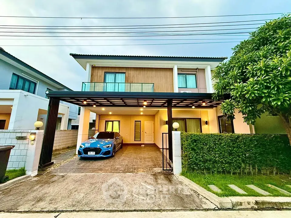 Modern two-story house with carport and lush greenery