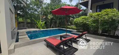 Luxurious private pool with sun loungers and lush greenery in a serene setting.