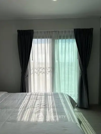 Bright bedroom with large window and elegant curtains