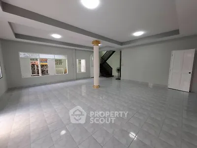 Spacious open-plan living area with tiled flooring and elegant column