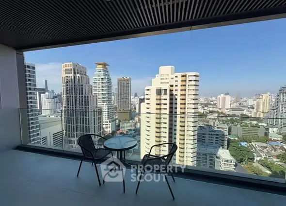 Stunning cityscape view from a modern balcony with seating area.