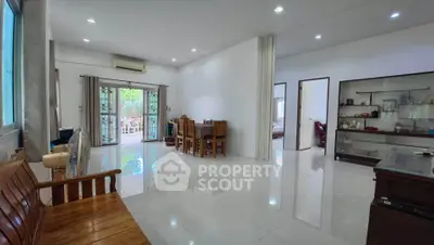 Spacious living room with elegant wooden furniture and large windows for natural light.