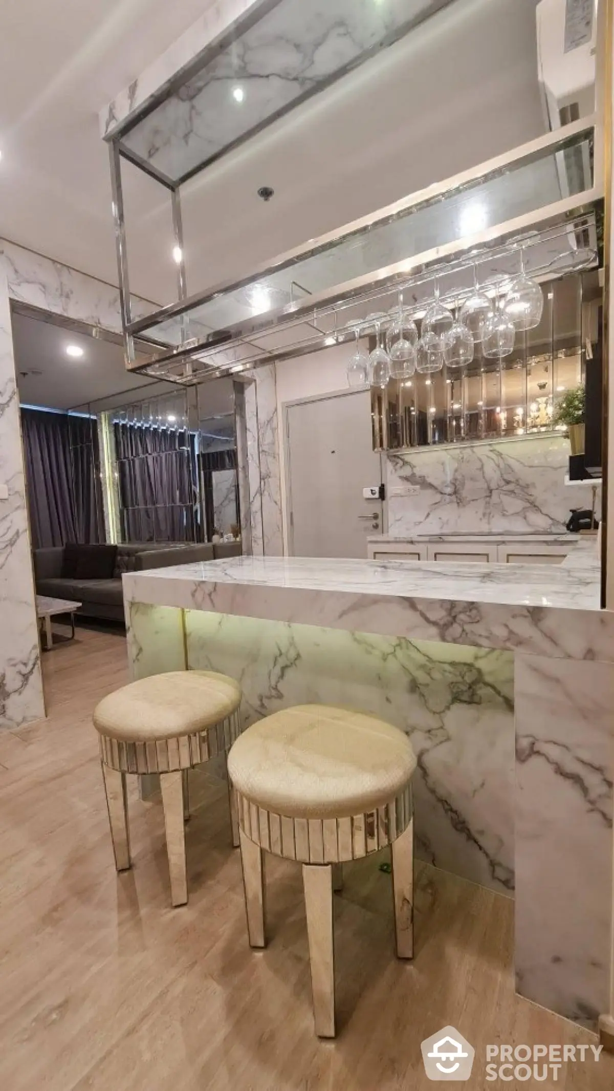 Luxurious marble kitchen with elegant bar stools and hanging glass rack