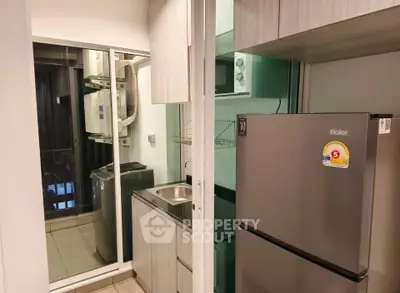 Modern kitchen with sleek appliances and compact design, featuring a stainless steel fridge and washing machine.