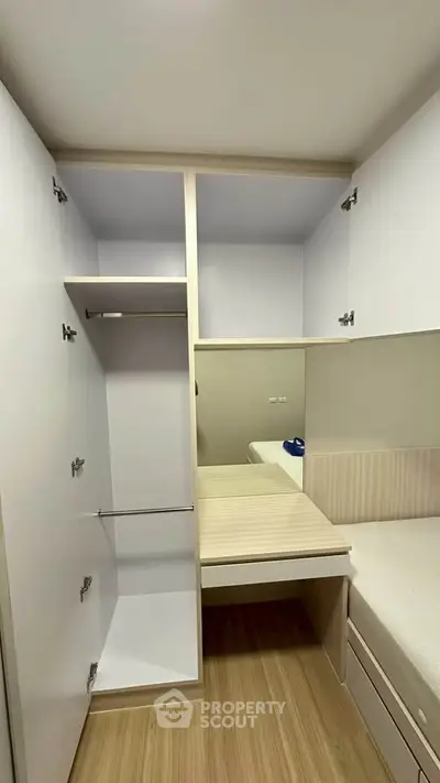 Compact bedroom with built-in wardrobe and wooden flooring, ideal for maximizing space in modern apartments.