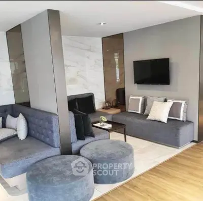 Modern living room with stylish seating and wall-mounted TV