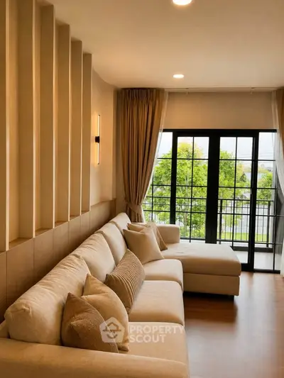 Elegant living room with cozy beige sofa and large windows opening to a scenic balcony view.