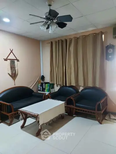 Cozy living room with elegant wooden furniture and ceiling fan, perfect for relaxation.