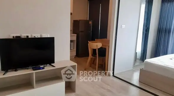 Modern studio apartment with open layout, featuring a cozy living area and compact kitchen.