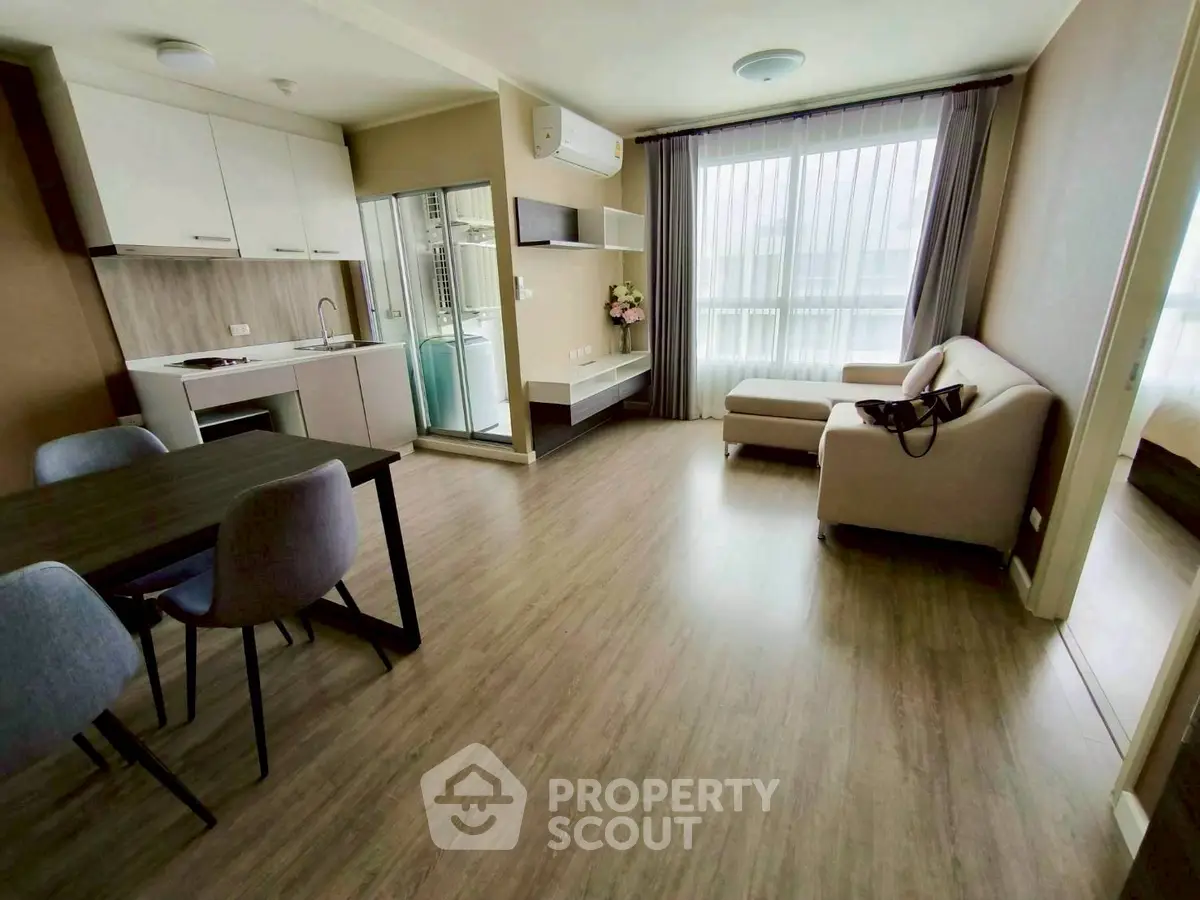 Modern living room with open kitchen and stylish furniture in a bright apartment.