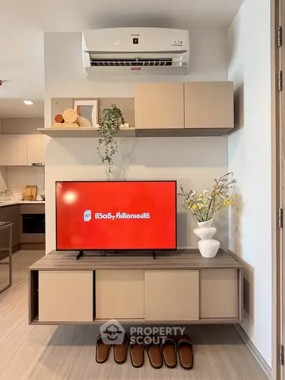 Modern living room with sleek furniture and air conditioning, showcasing a stylish TV setup and cozy ambiance.