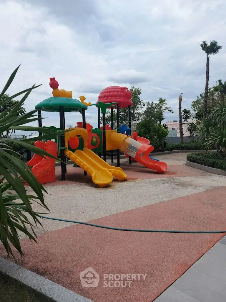 Vibrant playground in a lush garden setting with colorful slides and climbing structures.