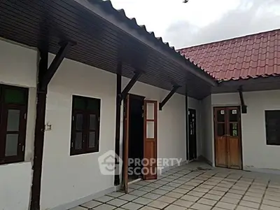 Charming single-story home with tiled patio and wooden doors, perfect for cozy living.
