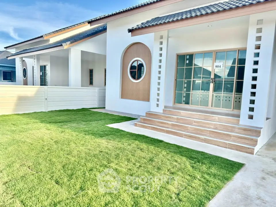 Charming modern house exterior with lush green lawn and stylish entrance steps.