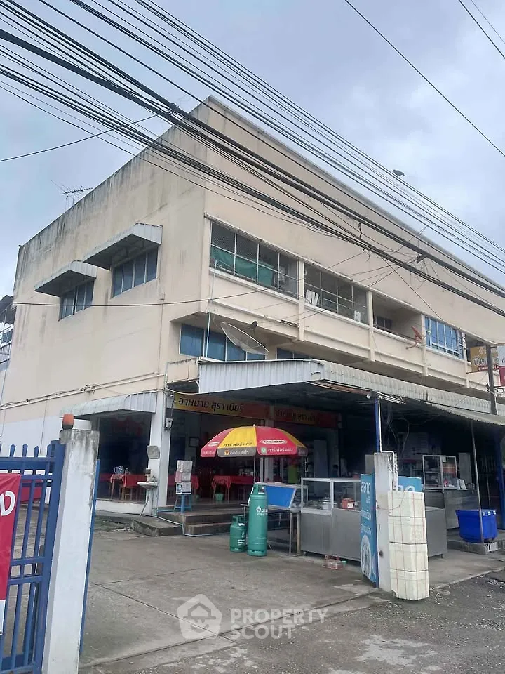 Commercial building with street view, featuring multiple floors and a small storefront.