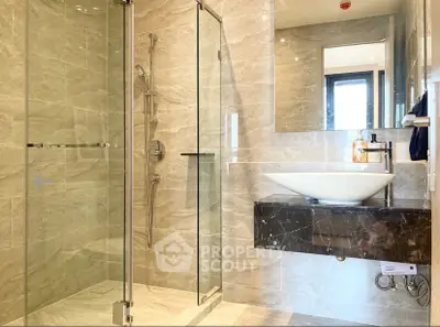 Modern bathroom with glass shower and elegant marble sink design.