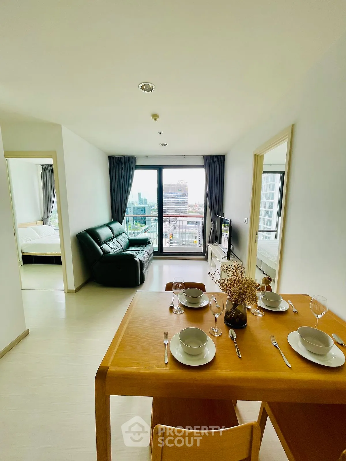Modern open-plan living room with dining area and city view