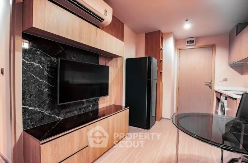 Modern living room with sleek design, featuring a wall-mounted TV, air conditioning, and stylish furniture.
