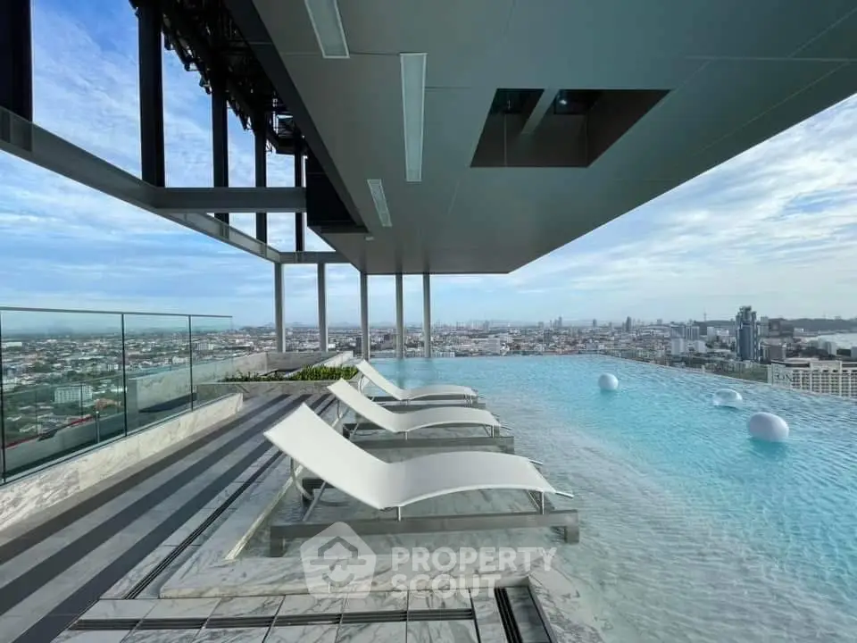 Stunning rooftop infinity pool with panoramic city views and modern lounge chairs.