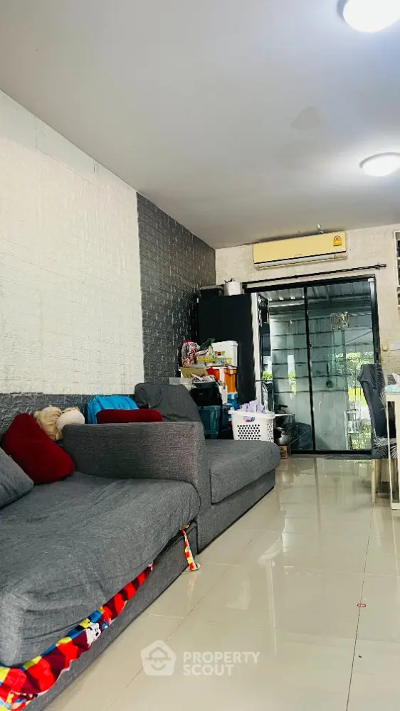 Spacious living room with modern gray sofa and glass sliding door