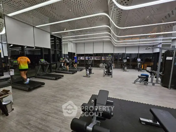 Spacious modern gym with state-of-the-art equipment and sleek design.