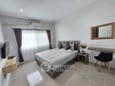 Modern bedroom with sleek design, featuring a comfortable bed, wall-mounted TV, and stylish decor.