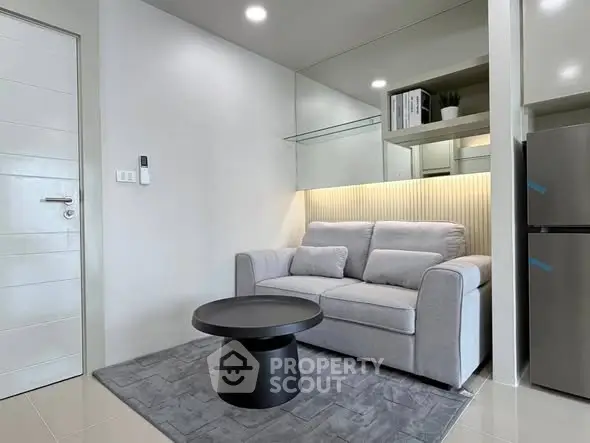 Modern living room with sleek gray sofa and stylish black coffee table in a cozy apartment.