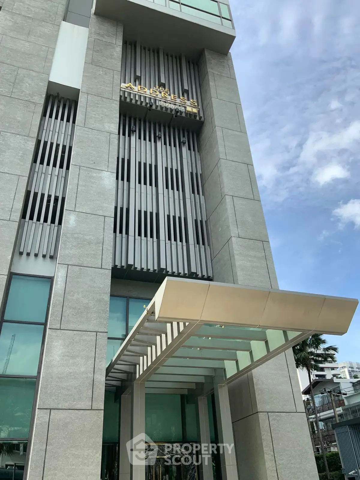 Modern building entrance with sleek architectural design and glass canopy.