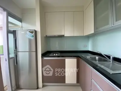 Modern kitchen with sleek cabinetry and stainless steel appliances in a compact layout.