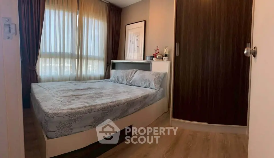 Cozy bedroom with large window and modern furnishings in a stylish apartment.