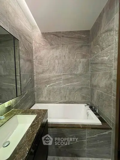 Luxurious bathroom with elegant marble tiles and modern bathtub design.