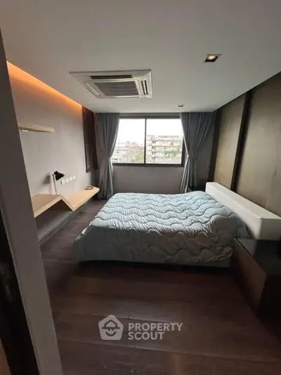 Modern bedroom with large window and stylish decor in urban apartment