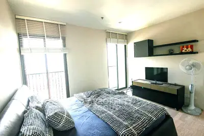 Modern bedroom with stylish decor, large windows, and sleek furniture in a contemporary apartment.