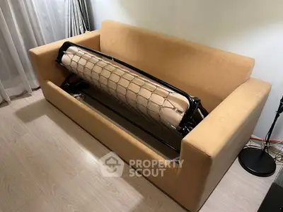 Modern sofa bed in a cozy living room setting with wooden flooring.