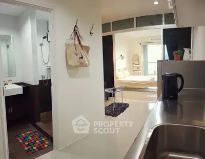 Modern apartment interior with open kitchen and cozy bedroom view