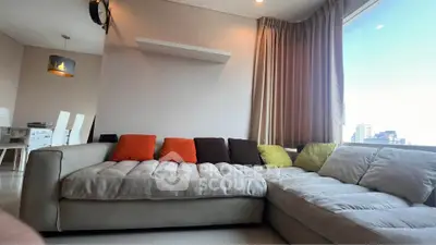 Spacious living room with modern L-shaped sofa and city view window