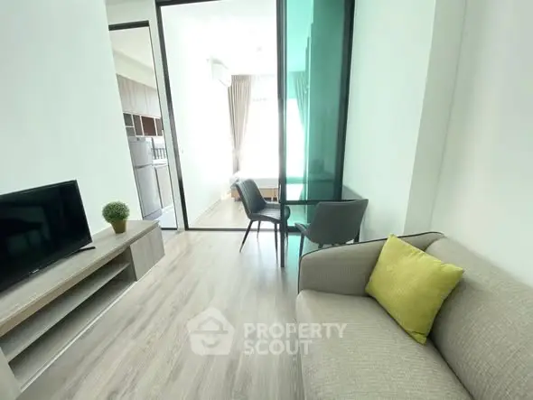 Modern living room with glass partition and cozy seating area.