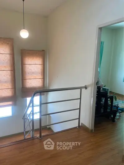 Bright interior with wooden flooring and modern railing, perfect for cozy living.