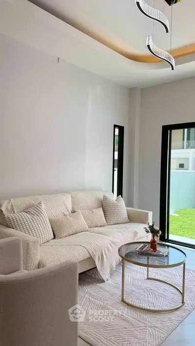 Modern living room with elegant decor and natural light, featuring a cozy sofa and stylish coffee table.