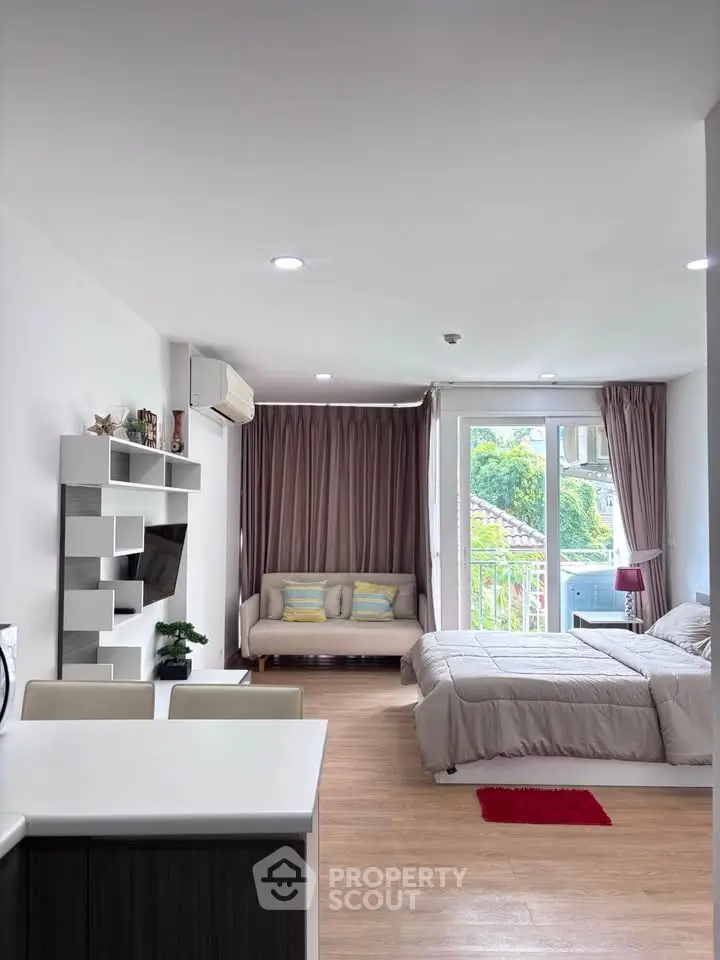 Modern studio apartment with open layout, featuring cozy living area and bedroom, large windows, and stylish decor.