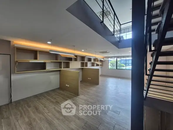 Modern open-plan office space with wooden flooring and ample natural light