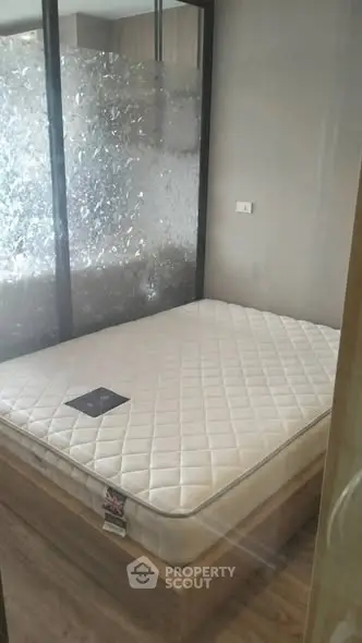 Modern bedroom with frosted glass partition and stylish wooden flooring