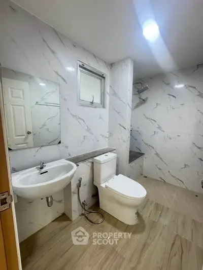 Modern bathroom with marble tiles and sleek fixtures in a contemporary home.