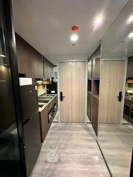 Modern kitchen with sleek appliances and wooden cabinetry in a compact layout.