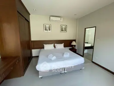 Spacious bedroom with modern decor and ensuite bathroom in a stylish apartment.