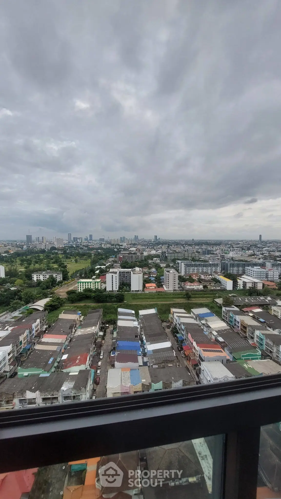 Stunning cityscape view from high-rise apartment window showcasing urban skyline.